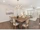 Elegant dining room features a wood table, chandelier, and seamless transition to the adjacent living area at 4141 Polluck Way, Charlotte, NC 28209