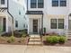 Home's entry with concrete steps, black handrail, and manicured garden featuring shrubs and flowers at 4141 Polluck Way, Charlotte, NC 28209