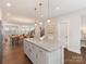 Bright kitchen island with bar stools opens to the dining room and living room beyond at 4141 Polluck Way, Charlotte, NC 28209