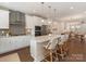 Open-concept kitchen with island seating, granite countertops, stainless steel appliances, and stylish pendant lighting at 4141 Polluck Way, Charlotte, NC 28209