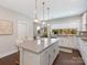 Spacious kitchen island with bar seating, ample storage, stainless appliances, and bright natural light at 4141 Polluck Way, Charlotte, NC 28209