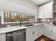 Modern kitchen sink with stainless steel appliances, white cabinetry, and a large window offering scenic views at 4141 Polluck Way, Charlotte, NC 28209