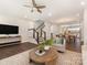 Spacious living room with hardwood floors, a staircase, and an open view into the dining and kitchen areas at 4141 Polluck Way, Charlotte, NC 28209