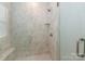 The glass enclosed shower features marble-like tile from floor to ceiling, a built-in seat and a shower niche at 4141 Polluck Way, Charlotte, NC 28209