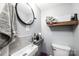 Modern bathroom with a sleek sink, round mirror, and convenient shelving for storage at 444 27Th Avenue Nw Cir, Hickory, NC 28601