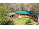 Charming brick home with a green roof, well-maintained lawn, and a cozy carport nestled in a serene wooded setting at 444 27Th Avenue Nw Cir, Hickory, NC 28601