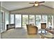 Bright living room with large windows offering stunning lake views and comfortable wicker seating at 458 Pinehaven Dr, Badin Lake, NC 28127