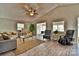 A bright living room features wood floors, a ceiling fan and multiple seating options at 458 Pinehaven Dr, Badin Lake, NC 28127