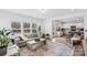 Open-concept living room connected to a modern kitchen, featuring hardwood floors and large windows at 5104 Thomasville Dr, Belmont, NC 28012