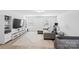 Bright living room featuring a gray sectional sofa, large television, neutral rug, and light-colored floors at 5104 Thomasville Dr, Belmont, NC 28012