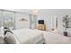 Bright primary bedroom featuring a large bed, natural light, wooden nightstand and decorative shelf with photos at 5104 Thomasville Dr, Belmont, NC 28012