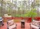 Cozy deck seating area with chairs, a table, and serene wooded views at 6108 Mcilwaine Rd, Huntersville, NC 28078