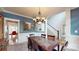 Elegant dining room with stylish chandelier, wainscoting and stairway access at 6108 Mcilwaine Rd, Huntersville, NC 28078