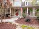Inviting front exterior with a red door, stone accents, and an American flag on the porch at 6108 Mcilwaine Rd, Huntersville, NC 28078