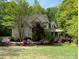 Charming two-story home with manicured lawn and vibrant flowerbeds, surrounded by lush trees at 6108 Mcilwaine Rd, Huntersville, NC 28078