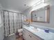 Bright bathroom features a blue vanity and white shower curtain, offering a clean design at 615 Ridgeway Dr, Belmont, NC 28012
