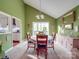 Sunlit dining room with green walls, neutral carpet, and a classic chandelier above the table at 615 Ridgeway Dr, Belmont, NC 28012