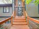 Inviting front entrance with wooden steps and modern railing, leading to a glass-paneled front door at 615 Ridgeway Dr, Belmont, NC 28012