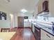 Well-lit kitchen with stainless steel appliances, white cabinets, dark countertops, and wood-look flooring at 615 Ridgeway Dr, Belmont, NC 28012