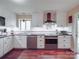 Bright kitchen featuring white cabinets, subway tile backsplash, stainless steel appliances, and dark countertops at 615 Ridgeway Dr, Belmont, NC 28012