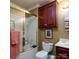 Traditional bathroom with tiled shower, cherry cabinets, and modern fixtures at 6307 Roanoke Dr # 17, Kannapolis, NC 28081