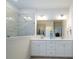 Bathroom with double sinks, large mirror, white cabinets and glass shower enclosure at 7036 Heron Rookery Way, Charlotte, NC 28214