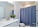 Bathroom featuring single sink vanity, framed mirror, and shower with blue curtain at 7036 Heron Rookery Way, Charlotte, NC 28214