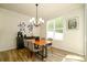 Bright dining room with modern light fixture, gray chairs, and wood flooring at 7036 Heron Rookery Way, Charlotte, NC 28214