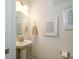 Stylish powder room featuring a pedestal sink, elegant mirror and coordinated decor at 7036 Heron Rookery Way, Charlotte, NC 28214