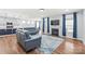 Open-concept living room featuring hardwood floors, blue sofas, fireplace, and modern decor at 7662 Tanglewood Way, Denver, NC 28037