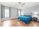Bright main bedroom featuring a ceiling fan, neutral walls, and hardwood floors at 7662 Tanglewood Way, Denver, NC 28037