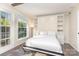 Bright bedroom featuring a built-in bed frame, with a large window offering natural light and light hardwood floors at 8308 Knights Bridge Rd, Charlotte, NC 28210