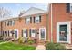 Charming brick townhome featuring black shutters, a landscaped yard, and a welcoming front entrance at 8308 Knights Bridge Rd, Charlotte, NC 28210