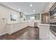Bright kitchen showcasing stainless appliances, white cabinetry, and stunning hardwood floors at 8308 Knights Bridge Rd, Charlotte, NC 28210