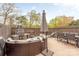 Outdoor patio with stone fireplace, seating, dining table, and umbrella for relaxing and entertaining guests at 8308 Knights Bridge Rd, Charlotte, NC 28210