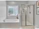 Bright bathroom with a soaking tub, glass shower, and natural light from a block window at 835 Ryans Pl, Fort Mill, SC 29715