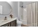 Clean bathroom featuring a shower-tub combo and a sleek, round mirror at 835 Ryans Pl, Fort Mill, SC 29715