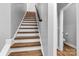 Bright staircase featuring wood treads, white risers, and a simple wooden handrail at 835 Ryans Pl, Fort Mill, SC 29715