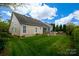 A well-manicured lawn and backyard with an outdoor stone kitchen and screened-in porch at 8621 Sequoia Grove Ln, Charlotte, NC 28214