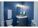 Modern powder room with dark blue walls, vanity, and a well-lit mirror and stylish fixtures at 8621 Sequoia Grove Ln, Charlotte, NC 28214