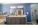 Well-lit bathroom with blue walls, double vanity, and a separate glass enclosed shower at 8621 Sequoia Grove Ln, Charlotte, NC 28214