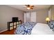 Cozy bedroom features hardwood floors, a ceiling fan, and storage, with blue patterned bedspread and muted wall color at 8621 Sequoia Grove Ln, Charlotte, NC 28214