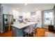 Bright, updated kitchen with white cabinetry, island seating, and stainless steel appliances at 8621 Sequoia Grove Ln, Charlotte, NC 28214