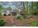 Backyard with a stone-lined path, flowering shrubs, and a screened-in porch, creating a private outdoor oasis at 9118 Pine Springs Ct, Huntersville, NC 28078