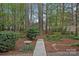 Tranquil backyard with a wooden bridge, a birdbath, and mature trees, offering a peaceful retreat at 9118 Pine Springs Ct, Huntersville, NC 28078