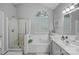 Modern bathroom with a soaking tub, separate shower, and a large window for natural light at 9118 Pine Springs Ct, Huntersville, NC 28078