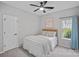 Comfortable bedroom with neutral tones, featuring a ceiling fan and a window with outdoor views at 9118 Pine Springs Ct, Huntersville, NC 28078