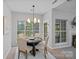 Cozy dining room features an elegant chandelier, table setting, and large windows with wooded views at 9118 Pine Springs Ct, Huntersville, NC 28078