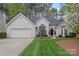 Charming home featuring manicured front lawn, mature trees, and an attached two-car garage, offering curb appeal at 9118 Pine Springs Ct, Huntersville, NC 28078