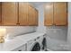 Functional laundry room with washer, dryer, and upper cabinets for storage at 9118 Pine Springs Ct, Huntersville, NC 28078